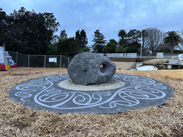The stone-and-plate sculpture under open sky