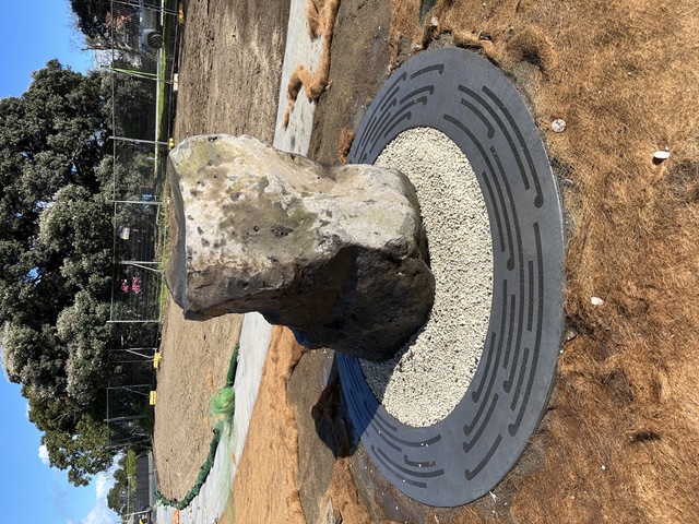 A rough standing stone on a circular perforated ground-plate